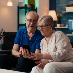 Old man and woman looking at smartphone screen Old man and woman looking at smartphone screen