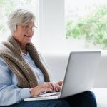 Smiling older woman using laptop Smiling older woman using laptop